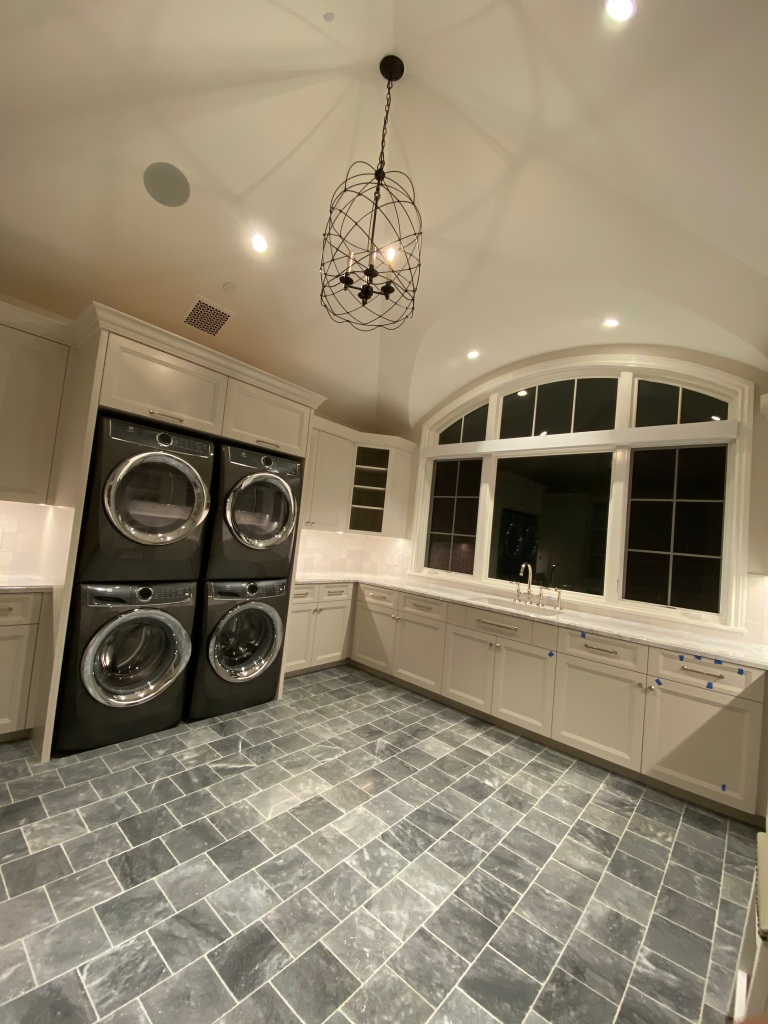 stacked washer and dryer, marble flooring, interior design, custom home, laundry room, transom window, granite countertops